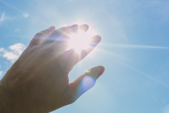Une main placée devant le soleil
