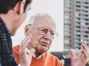 homme âgé discutant avec un autre, illustrant le service public départemental de l'autonomie
