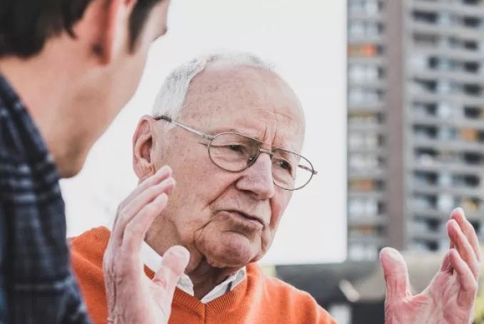 homme âgé discutant avec un autre, illustrant le service public départemental de l'autonomie